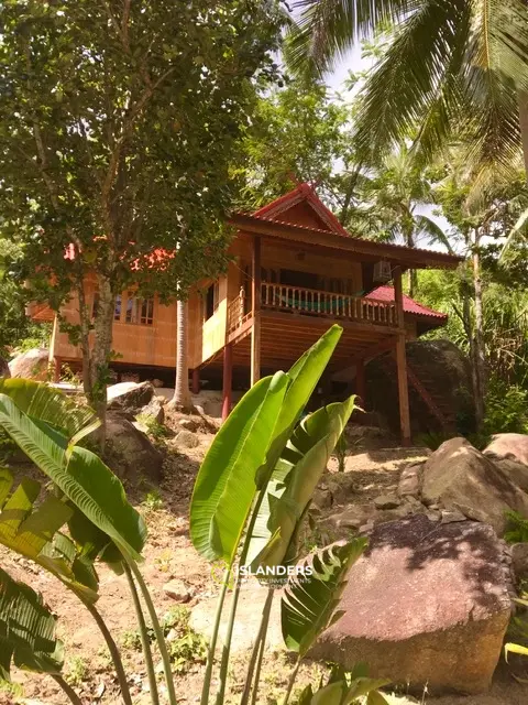 Casa de madera tradicional en un jardín impresionante.