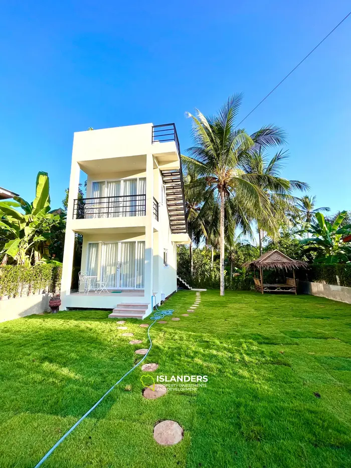 Casa moderna de dos plantas en un entorno tropical verde